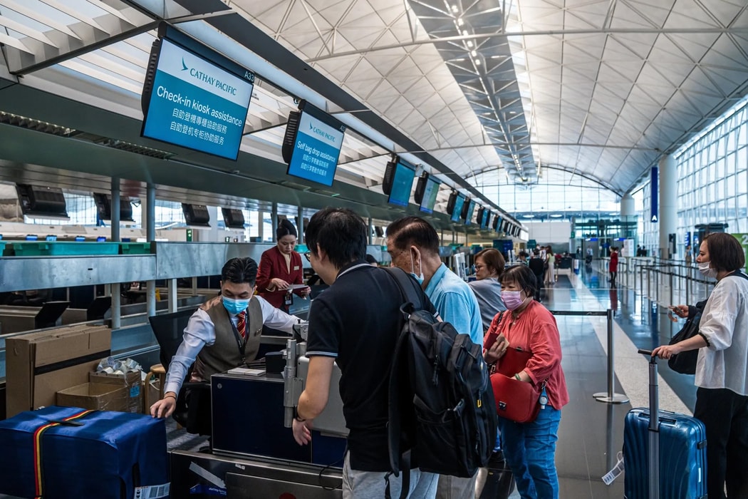 Hành khách làm thủ tục lên chuyến bay của Cathay Pacific. Hình ảnh: Lam Yik/Bloomberg
