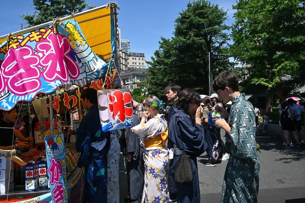 Du khách mặc kimono mua đá bào tại một quầy hàng ở khu Asakusa, Tokyo. Hình ảnh: Soichiro Koriyama/Bloomberg
