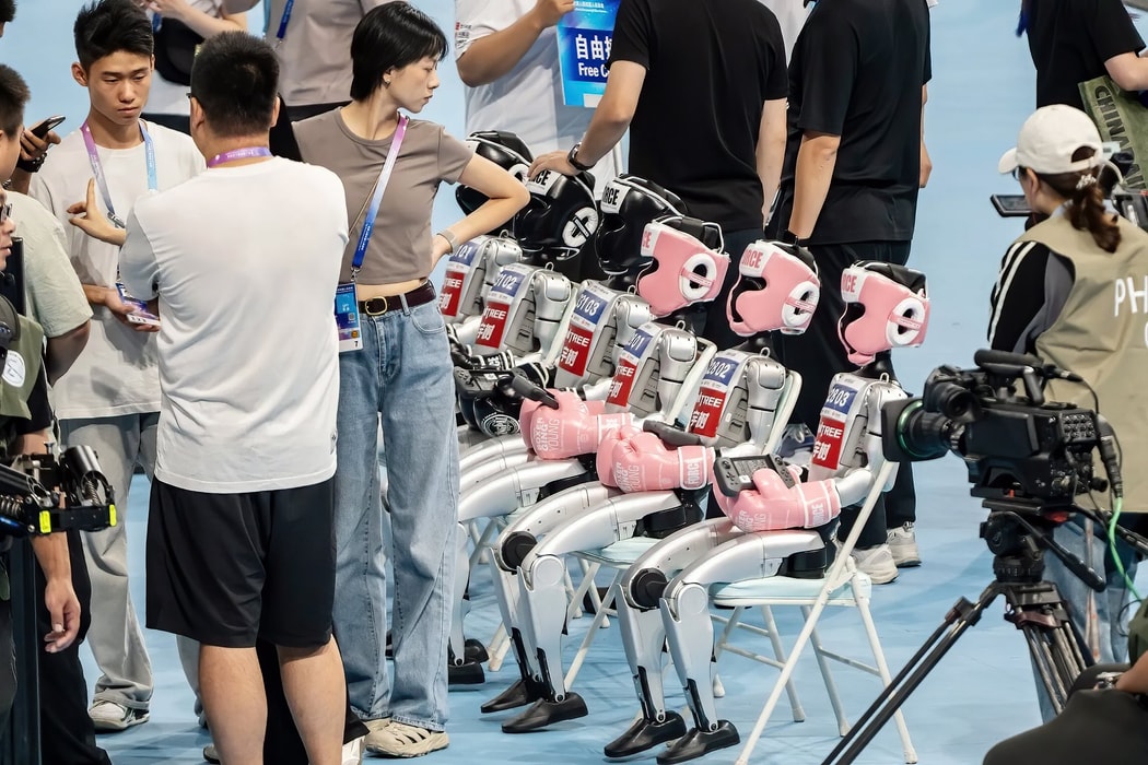 Các robot hình người của Unitree ngồi trên ghế trước một trận đấu kick-boxing tại Giải đấu Robot Hình người Thế giới. Hình ảnh: Qilai Shen/Bloomberg
